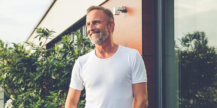Man in white T-shirt smiling on the balcony Man in white T-shirt smiling on the balcony