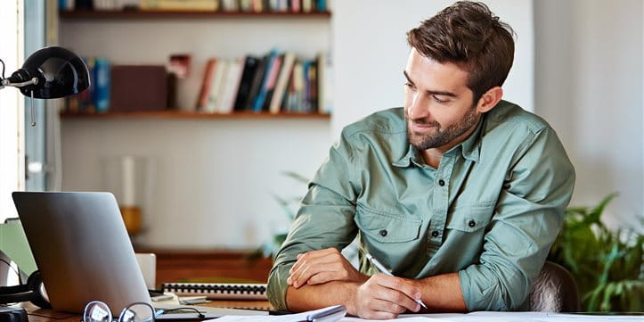 Mann sitzt am Schreibtisch und sucht nach Pensionskasse Mann sitzt am Schreibtisch und sucht nach Pensionskasse