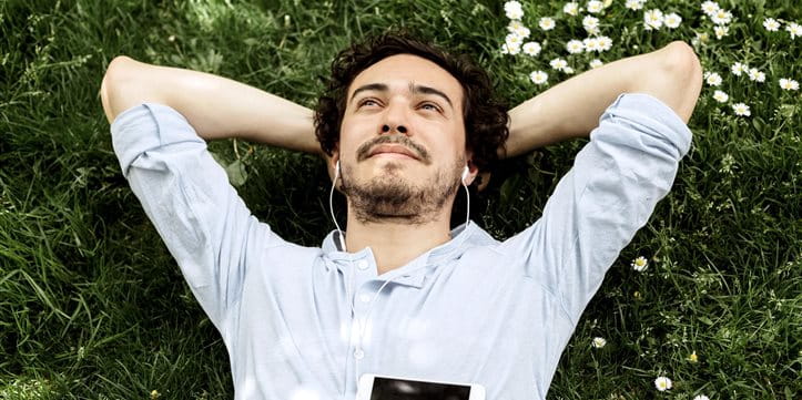 L'homme s'allonge sur la prairie, regarde le ciel et écoute de la musique. L'homme s'allonge sur la prairie, regarde le ciel et écoute de la musique.